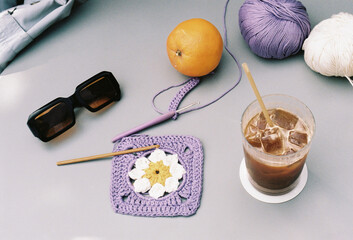 Creative crochet session with colorful yarn and refreshing drink