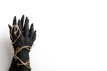Concept photo with woman hands painted in black paint with a rope wrapping her hands