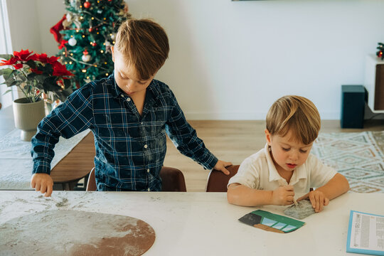 Focused boys carving and creating at home during festive holiday
