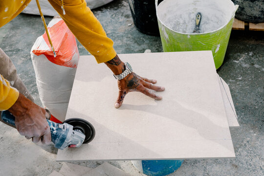 Anonymous man using a tile cutter to cut ceramic floors
