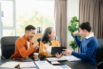Group of young Asian business people discussing business plan at modern startup