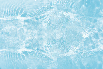Obraz premium Blue water with ripples on the surface. Defocus blurred transparent blue colored clear calm water surface texture with splashes and bubbles. Water waves with shining pattern texture background.