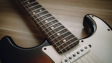 Close-up of electric guitar strings and pickups. Vintage style detail showing texture and craftsmanship of a classic musical instrument. Perfect for music, rock, or retro themes.