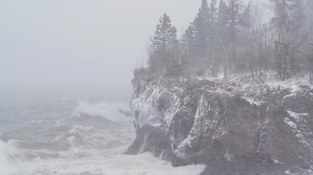 Waves Crashing On Snowy Cliff With Dense Fog And Blizzard On Rugged Shore Of Lake Superior In Minnesota. static shot