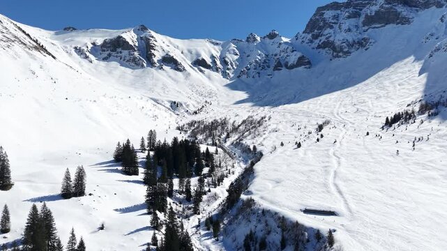 DJI Air 3s drone surfing over the Diemtigtal. Swiss mountain valley on a sunny winter day.