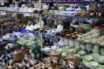 Colorful ceramic vases on shelves in a market