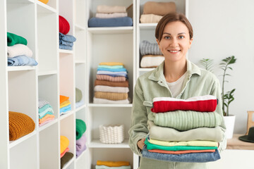 Young woman organizing clothes in dressing room