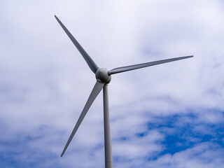 Modern Wind Turbine Against a Blue Sky with White Clouds