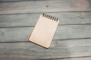 A spiral bound notebook sits on a wooden table