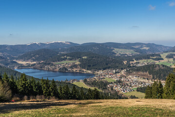 Fototapeta premium View of the Titisee lake and the spa town of the same name from Hochfirst, with the Feldberg lightly covered in snow in the background, Baden-Wuerttemberg, Germany