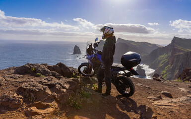 Obraz premium Enduro Motorcycle with Driver Posing on Sea Cliff , Madeira island