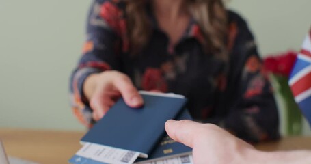 Travel agency manager issues tickets for traveling to other countries abroad. A girl gives a ticket to man for an airplane flight with a passport. Flight booking, travel, traveler get tickets