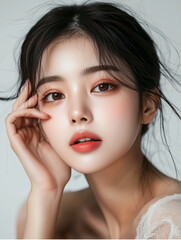 Naklejka premium Beautiful Korean woman showcasing flawless skincare in a close-up portrait with natural makeup and soft hair, in a serene setting