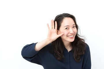 Fototapeta premium A Japanese woman in her thirties, smiling and making the 'peace' sign with one hand while holding