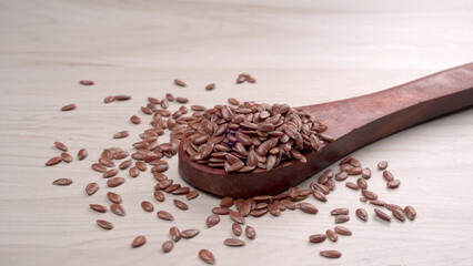 Brown flax seed or linseed on wooden background. Diet healthcare healthy food.