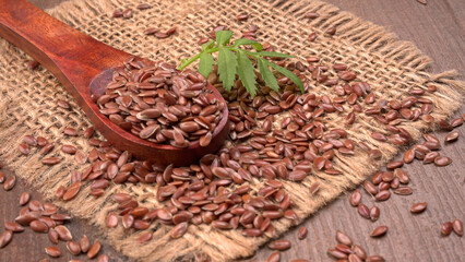 Brown flax seed or linseed on wooden background. Diet healthcare healthy food.