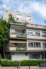 Fototapeta premium Wohnhaus mit bepflanzten Balkonen und verwitterter Fassade im Stadtviertel