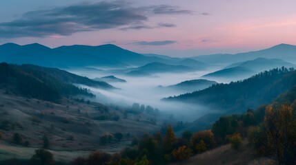 Fototapeta premium A serene mountain landscape with fog rolling through valleys at dusk with pastel sky above