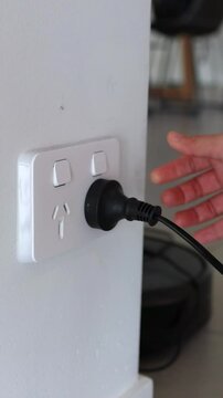 Hand Unplugging Cord from Wall Socket in Australia