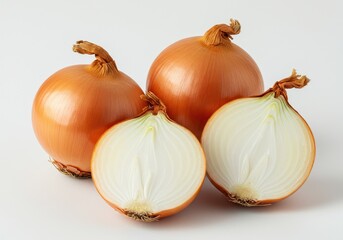 Fototapeta premium Two whole yellow onions and one onion cut in half on a white surface show the inside layers of the vegetable