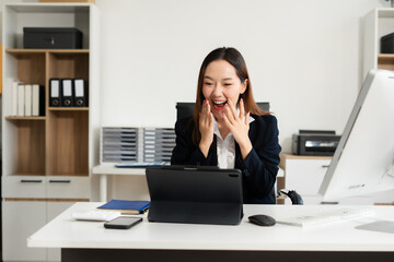 Excited Asian, business woman sitting at table feeling happy. woman overjoyed accepting mail at...