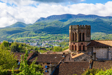 Romanesque cathedral of Saint-Lizier and its hexagonal brick bell tower with the green mountains of...