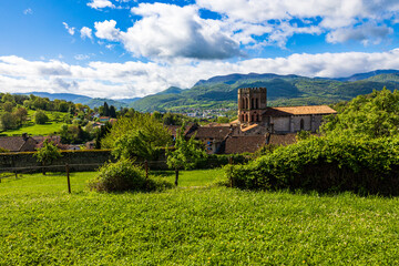Romanesque cathedral of Saint-Lizier and its hexagonal brick bell tower with the green mountains of...