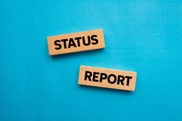 Status report message written on wooden blocks on blue background. Conceptual status report symbol. Copy space.