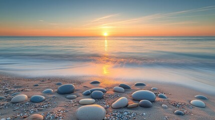 Obraz premium Sunset over calm ocean waves with pebbles on sandy beach