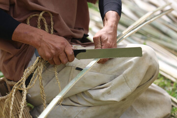 竹の長さを揃えて切る男性