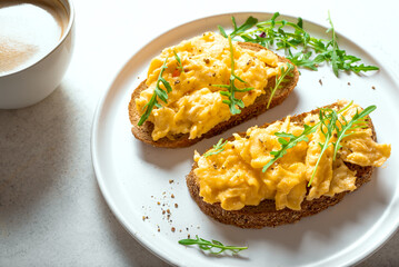 Scrambled Eggs sandwiches and cup of coffee for breakfast