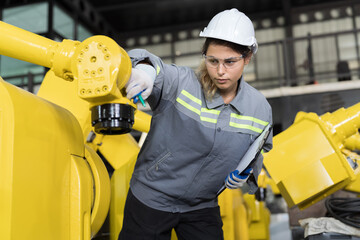 Automatic robotic arm, Storage warehouse. Woman engineer using clipboard check inventory robotics arms. Installation, testing or setting robotics arms