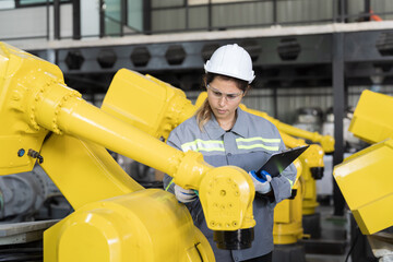 Automatic robotic arm, Storage warehouse. Woman engineer using clipboard check inventory robotics arms. Installation, testing or setting robotics arms