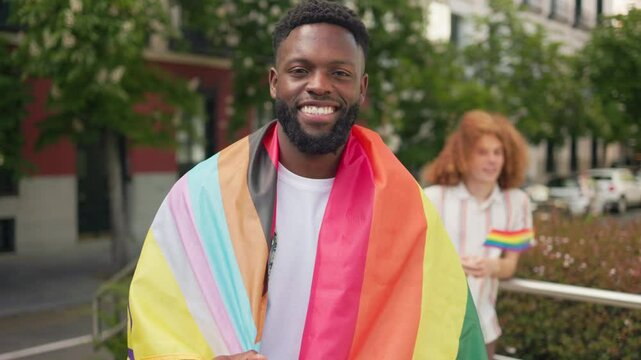 Portrait of smiling black man wrapped in rainbow flag