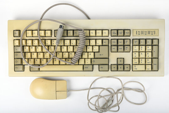 Vintage computer keyboard and mouse displaying wear from use