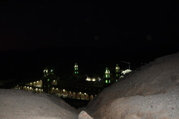 The ariel view at night of Aboul Hassan el Shazly Mosque in Homaithera in southern Egypt with its green lights shining the in middle of the hills and mountains