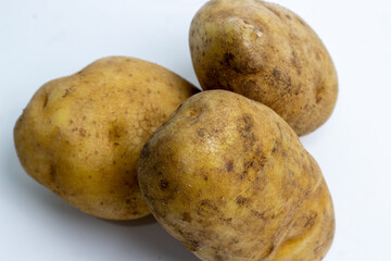 Fresh raw potatoes on white. Essential vegetable food ingredient for healthy cooking.