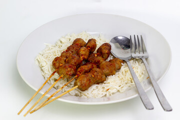 Moo Ping (Thai grilled pork) with rice. Delicious Asian meal on plate, ready to eat