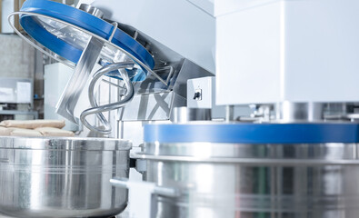 Industrial dough mixing machines in confectionery production facility, food industry factory.