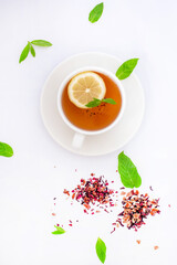 Fresh lemon slices on skewers and a cup of tea with mint and lemon, styled as a clean background image.