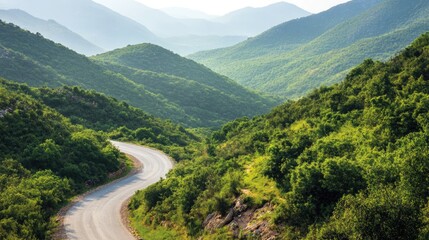 Fototapeta premium Winding Road Through Lush Green Mountains on a Sunny Day