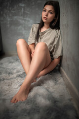 Naklejka premium Portrait of a young beautiful dark-haired girl in a home studio.