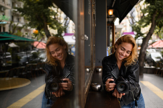 A female photographer with her camera on the streets of the city. A creative moment capturing the passion for photography and the vibrant atmosphere of urban life.