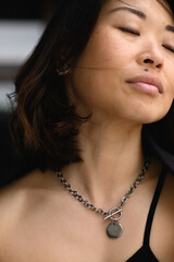 Close-up portrait of young Asian woman with natural expression. Beautiful skin, serene look,...
