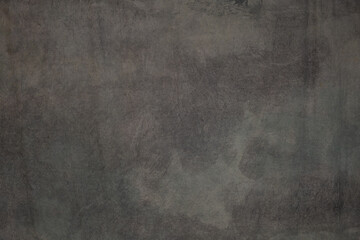 Dark textured fabric background featuring subtle folds and irregular patterns. Ideal for use in design projects, providing a rich and complex backdrop for various applications.