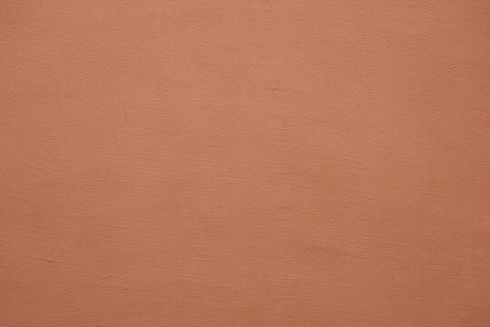 Coral stucco wall texture, peach fuzz color background. Abstract grunge artistic backdrop for design. Salmon color ribbed paper, pastel pink plaster, pattern.
