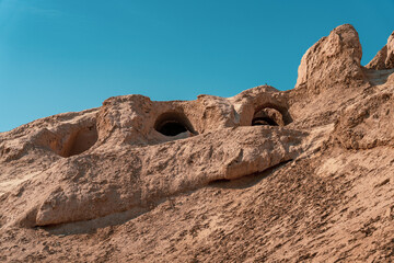 A rocky hill with a blue sky in the background