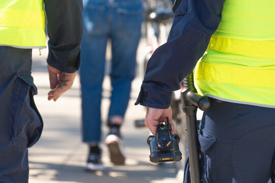 Police officers in yellow vests with body cameras walking in city street