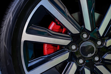 Car wheel with brake calipers and stylish design.