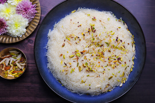 Closeup of Sutarfeni, a traditional Indian sweet made from fine sev soaked in sweet saffron flavored milk, garnished with dry fruits. Perfect for festive celebrations and Indian cuisine themes. copy